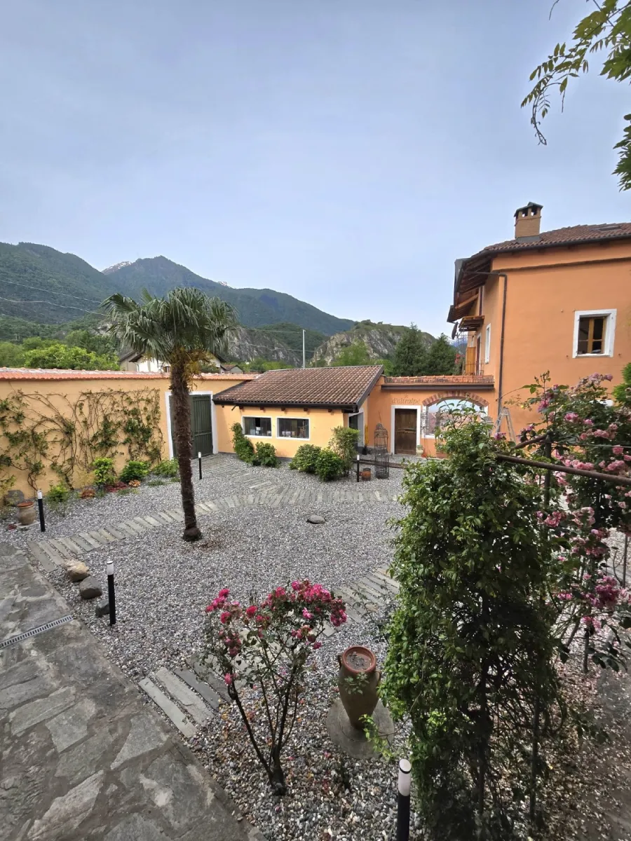 Cortile di una cascina con ghiaia e passi persi in pietra