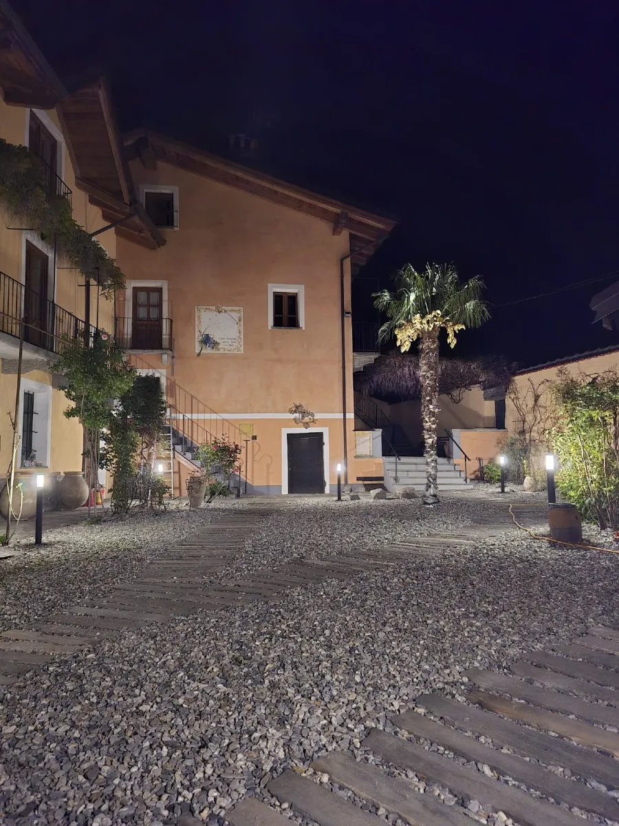 Visione notturna illuminata di un cortile in ghiaia con passi persi in pietra